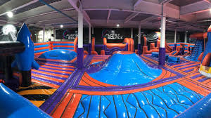 Indoor inflatable park with obstacle courses and slides at Planet Bounce