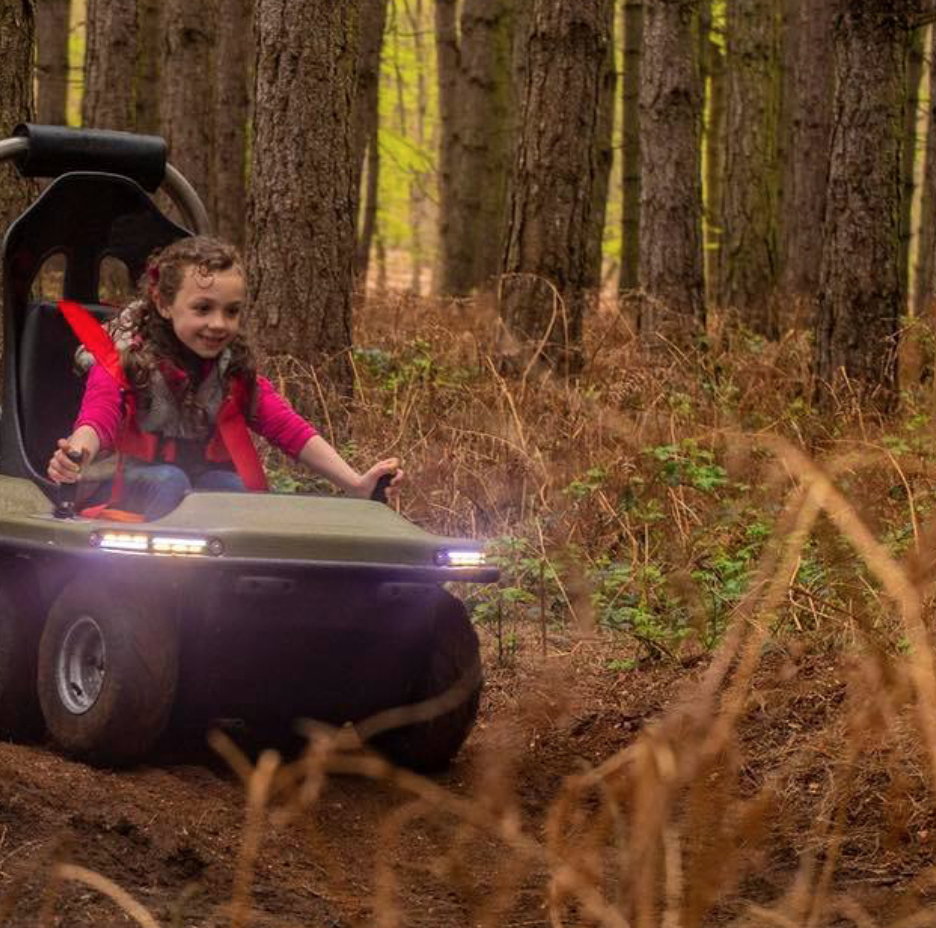 Children riding quad bikes on woodland track