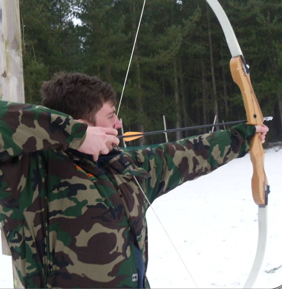 Archers aiming at targets in forest setting